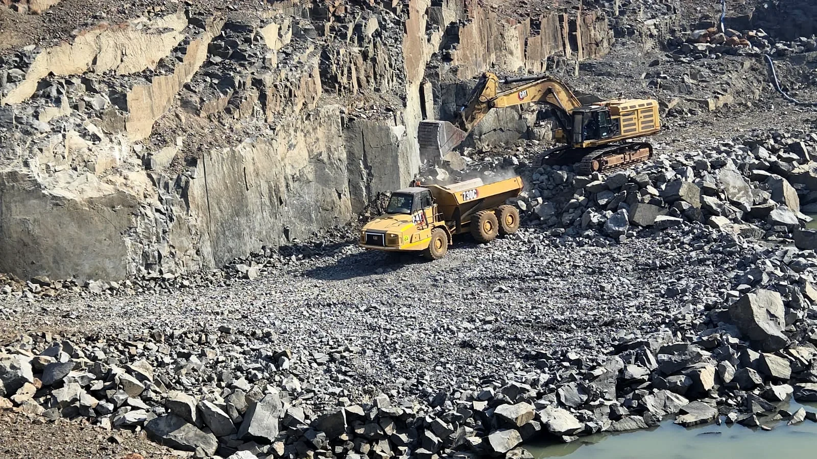CAT excavator and articulated dump truck in the Mashavane quarry