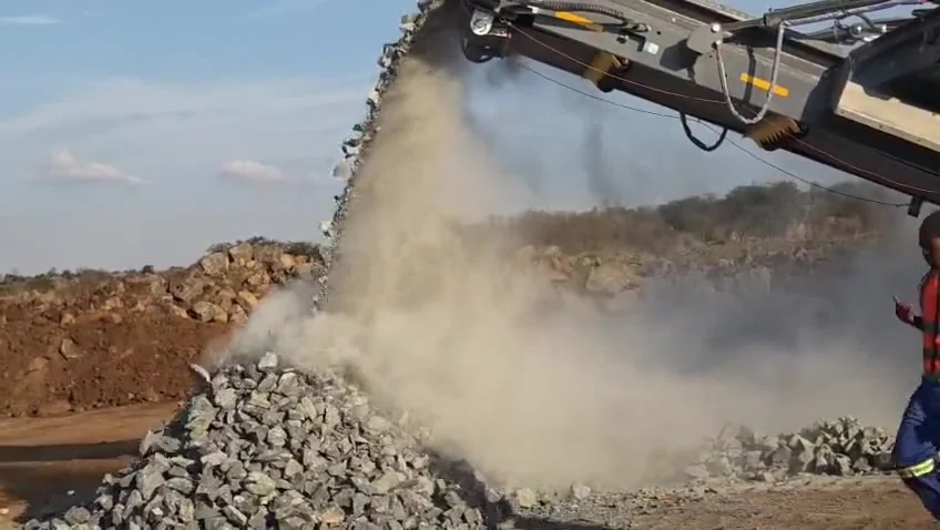 Conveyor discharging processed stone